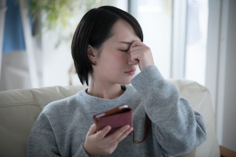 目をおさえる女性